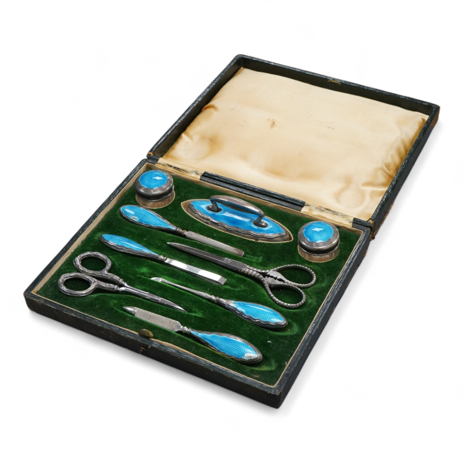 A cased George V eight piece (ex 9 piece) manicure and toilet jar set, comprising seven silver and enamel mounted items, Boots Pure Drug Company, Chester and Birmingham, 1910, together with a matching pair of steel sciss